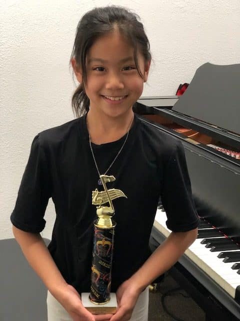 Student proudly holding an award