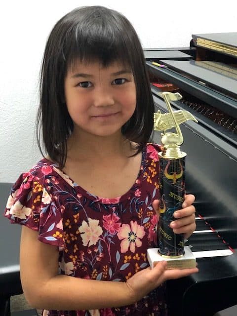Student proudly holding an award