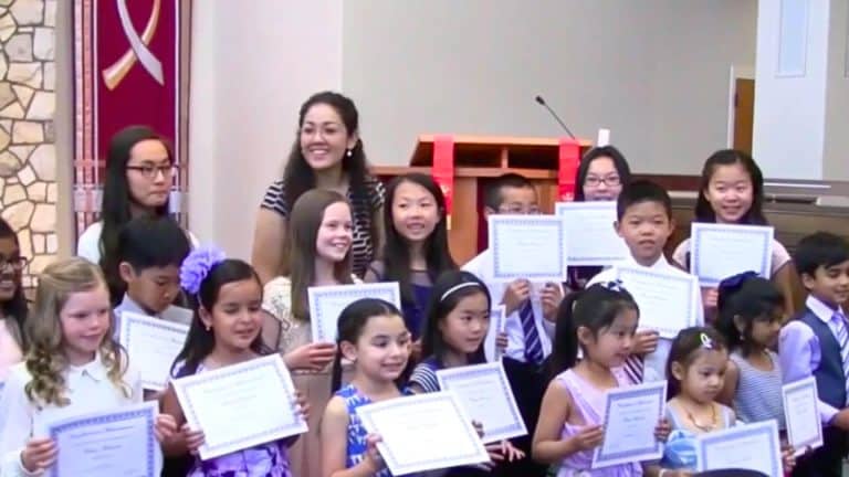 Group of young music students holding certificates after a recital