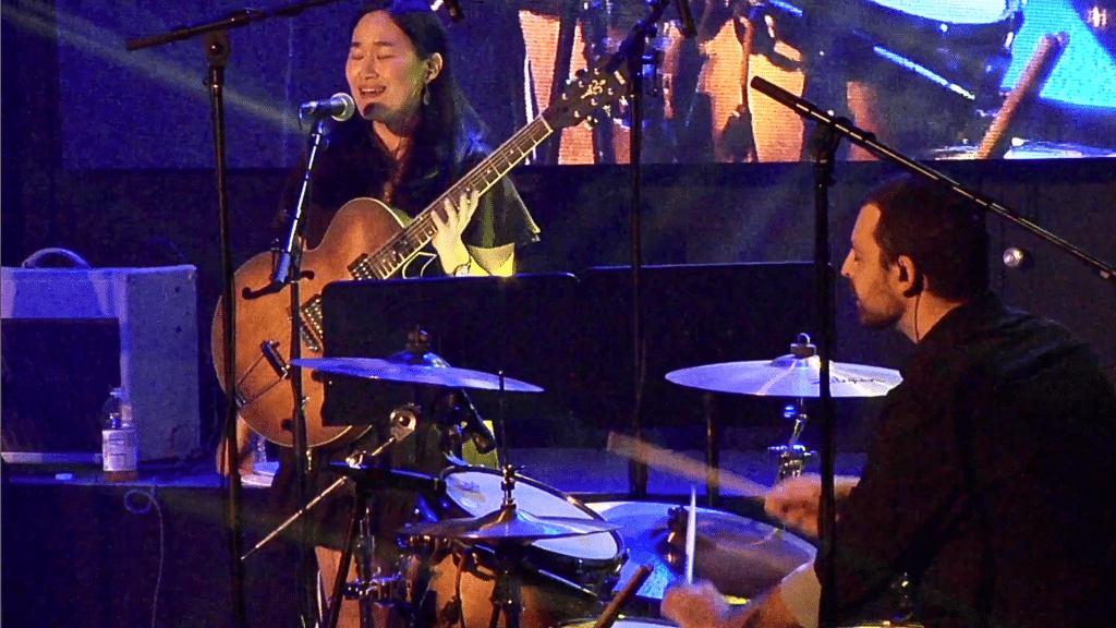 Matt and Joyce performing live with guitar and drums