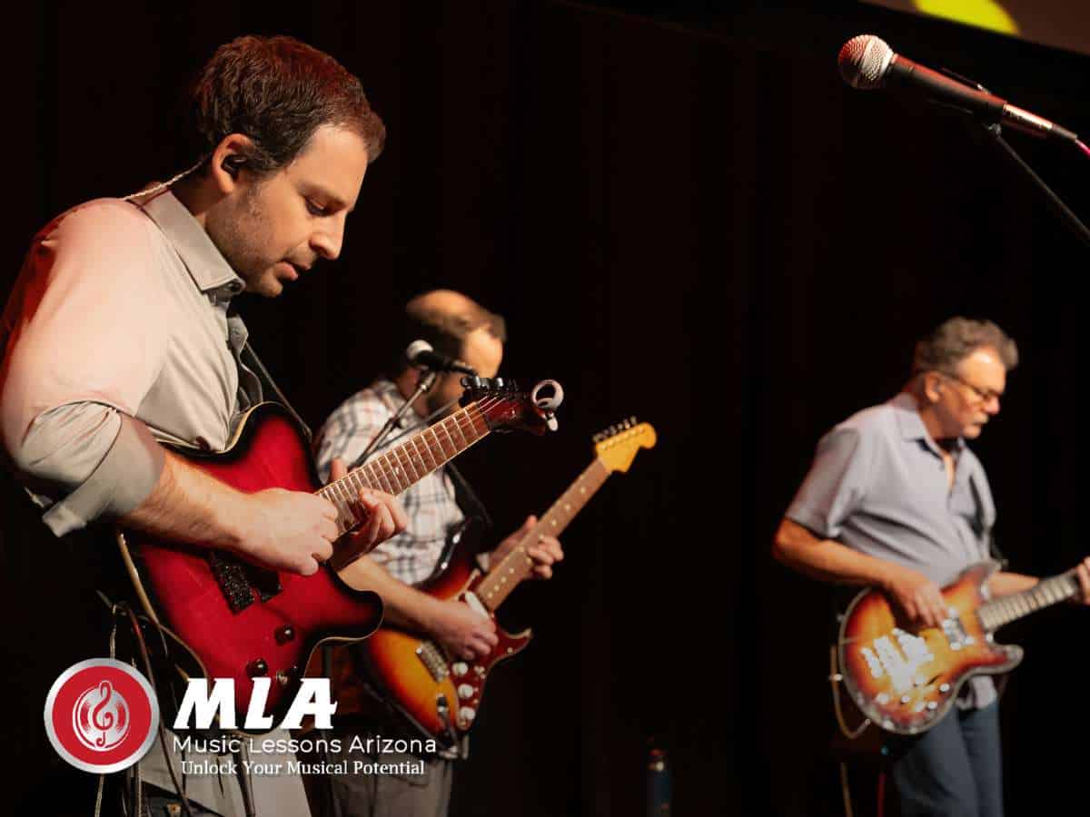 Adult Music Classes guitarists performing together on stage